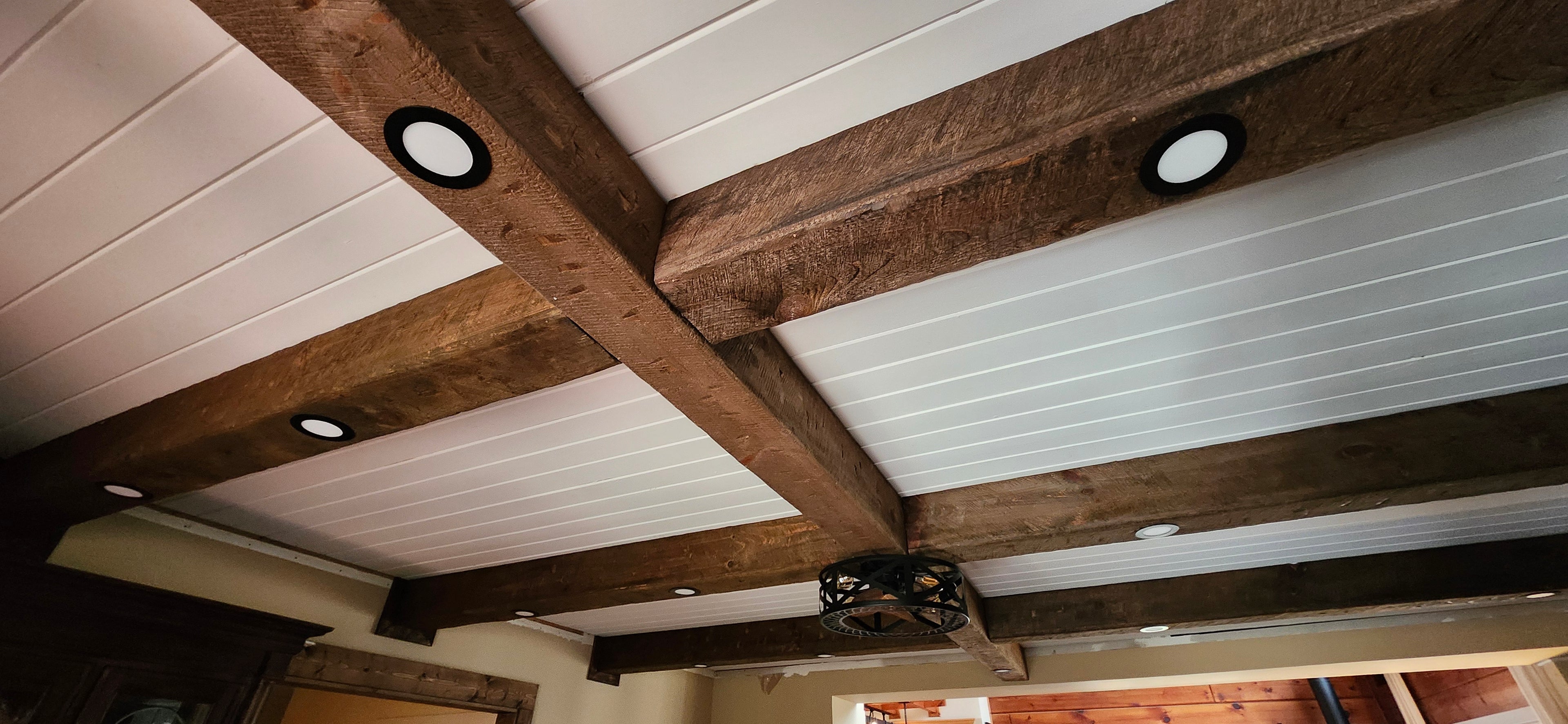 Custom made exposed architectural wood ceiling beams. They are hollow and have a rustic, distressed, rough sawn, aged and antique wood treatment to have the look of an old barn beam.
